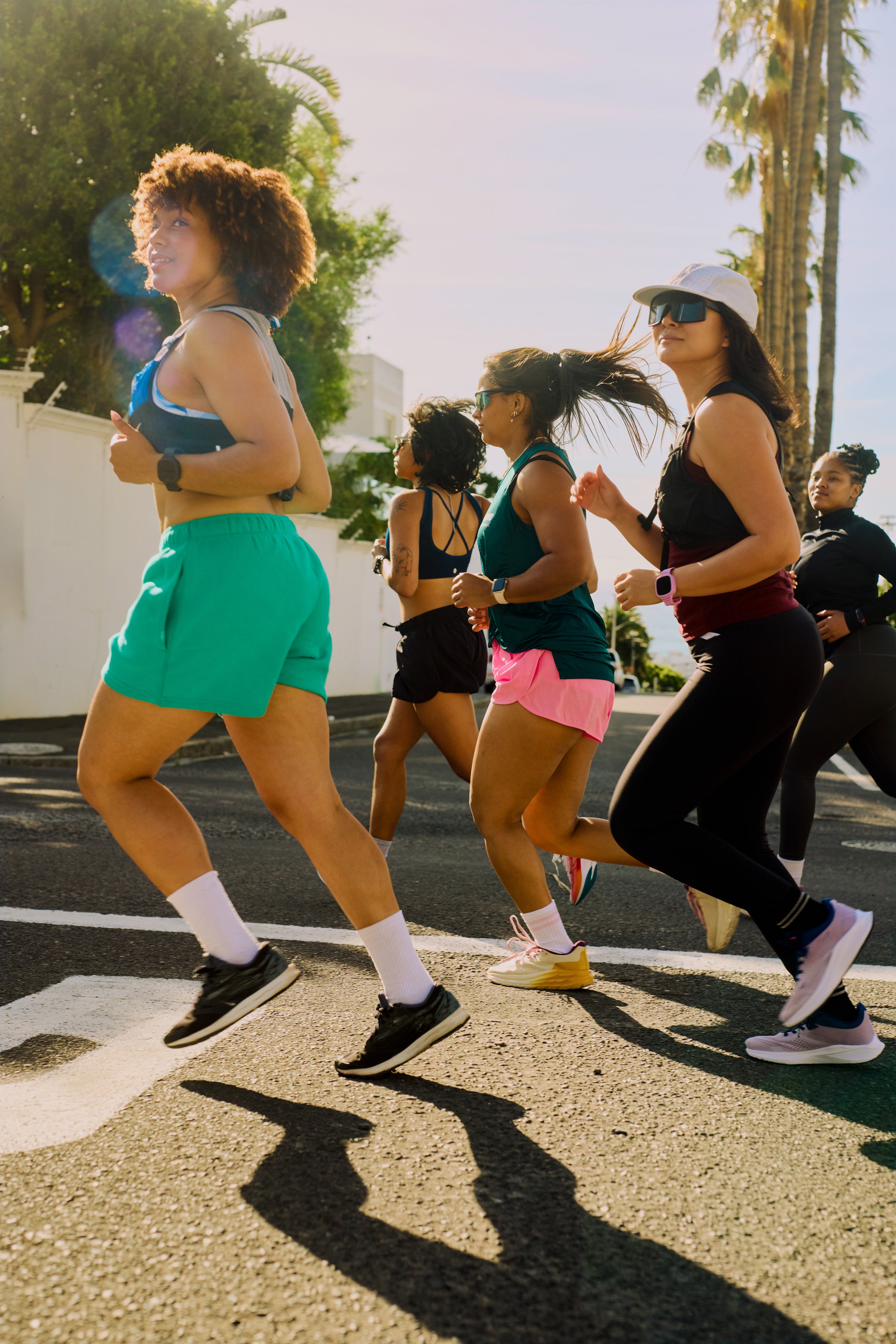 Group of women running outdoors on a sunny day with ekai drinks